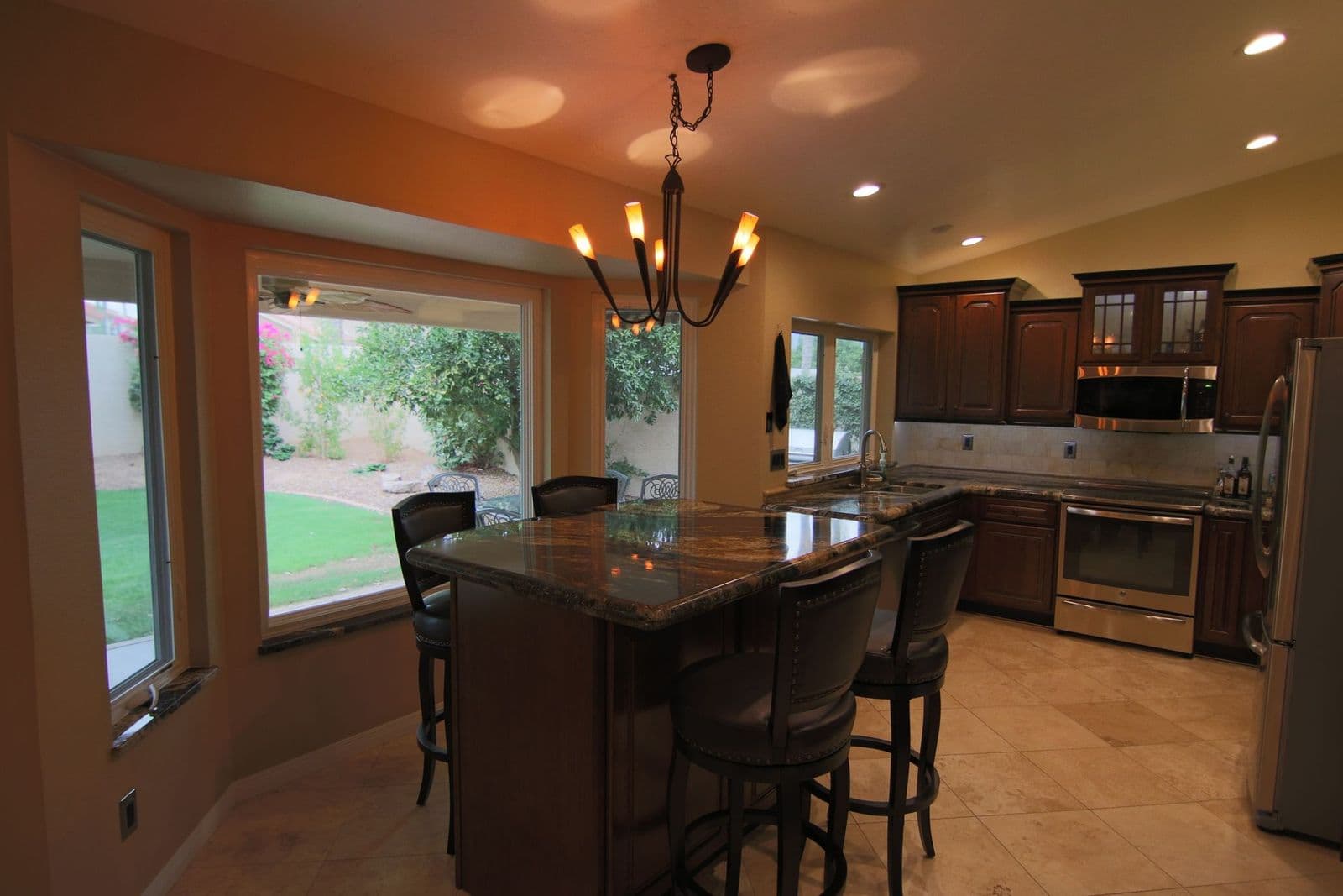 Remodeled kitchen with dark cabinets, a granite island and bar seating