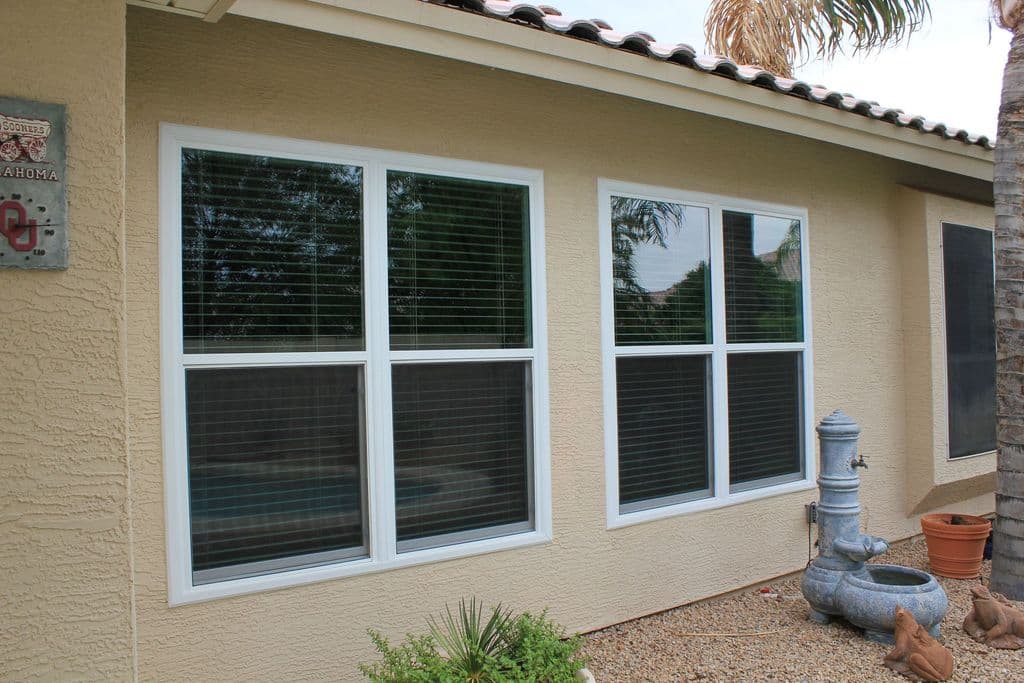 Finished stucco wall around new white windows