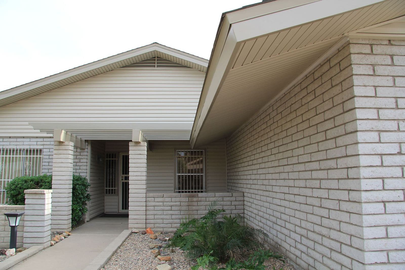 Covered entry with a sided gable, painted brick and a new soffit