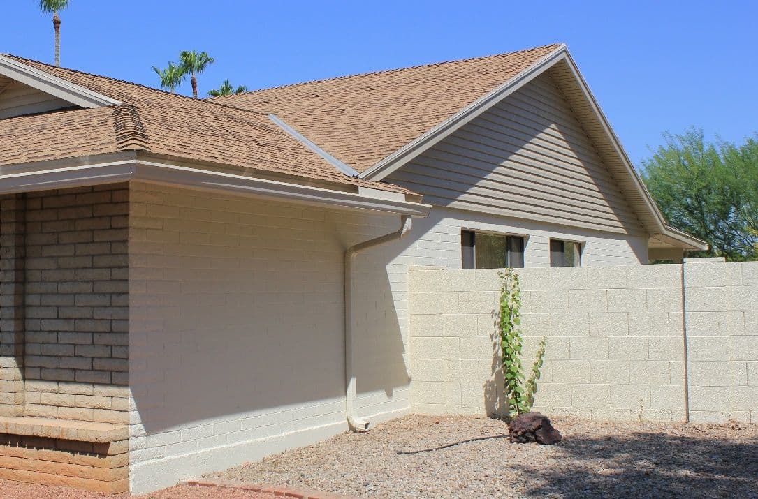 Ranch home with a gray sided gable, brick and a block wall
